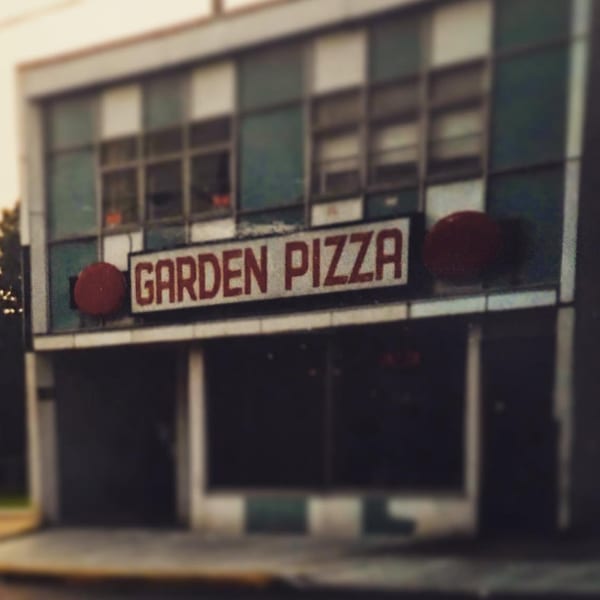 Exterior of the Roman Pizza & Restaurant building with a "GARDEN PIZZA" sign.